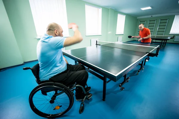 Adulto discapacitado en silla de ruedas jugar al tenis de mesa con su entrenador —  Fotos de Stock