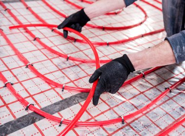 Boru tesisatçısı, alt kattaki ısıtma sistemini eve kurar