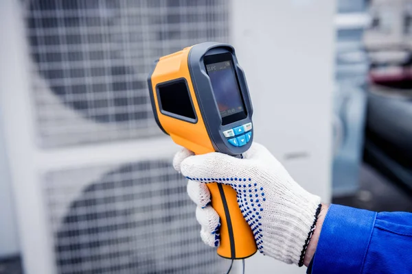 Técnico utiliza un termómetro infrarrojo de imagen térmica para comprobar el intercambiador de calor de la unidad de condensación. —  Fotos de Stock