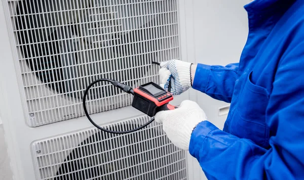 El técnico utiliza una cámara digital para comprobar la obstrucción del intercambiador de calor —  Fotos de Stock