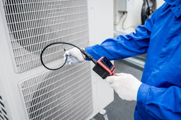 El técnico utiliza una cámara digital para comprobar la obstrucción del intercambiador de calor —  Fotos de Stock