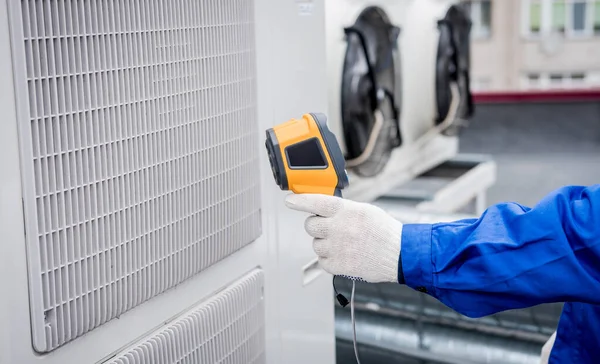 Técnico utiliza un termómetro infrarrojo de imagen térmica para comprobar el intercambiador de calor de la unidad de condensación. —  Fotos de Stock