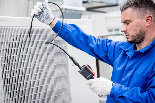 El técnico utiliza una cámara digital para comprobar la obstrucción del intercambiador de calor —  Fotos de Stock