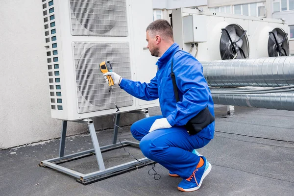 Técnico utiliza un termómetro infrarrojo de imagen térmica para comprobar el intercambiador de calor de la unidad de condensación. —  Fotos de Stock