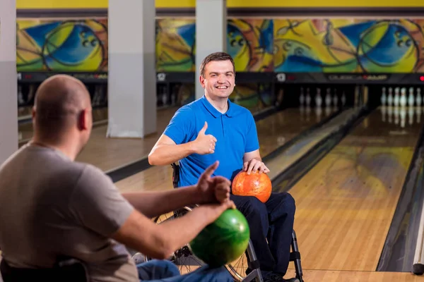 Dva mladí zdravotně postižení muži na vozíčku hrají bowling v klubu — Stock fotografie