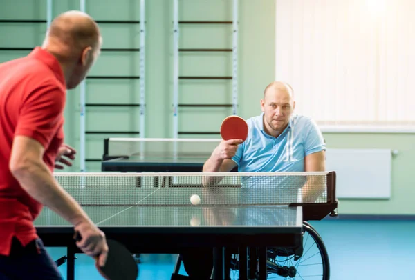 Adulto discapacitado en silla de ruedas jugar al tenis de mesa con su entrenador — Foto de Stock