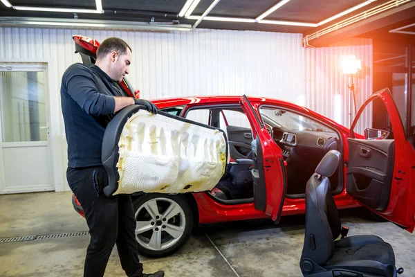 Bilservicearbetare monterar isär bilens inre delar — Stockfoto
