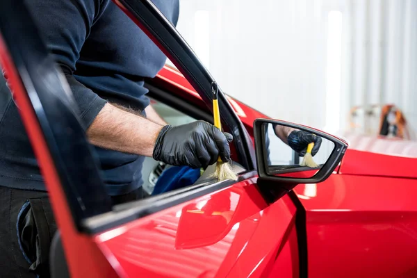 Car service worker cleans interiror with special brush — Stock Photo, Image