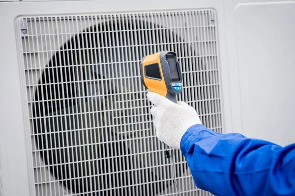 Técnico utiliza un termómetro infrarrojo de imagen térmica para comprobar el intercambiador de calor de la unidad de condensación. —  Fotos de Stock