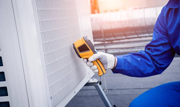 Técnico utiliza un termómetro infrarrojo de imagen térmica para comprobar el intercambiador de calor de la unidad de condensación. —  Fotos de Stock