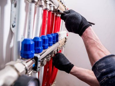 Boru tesisatçısı, alt kattaki ısıtma sistemini eve kurar