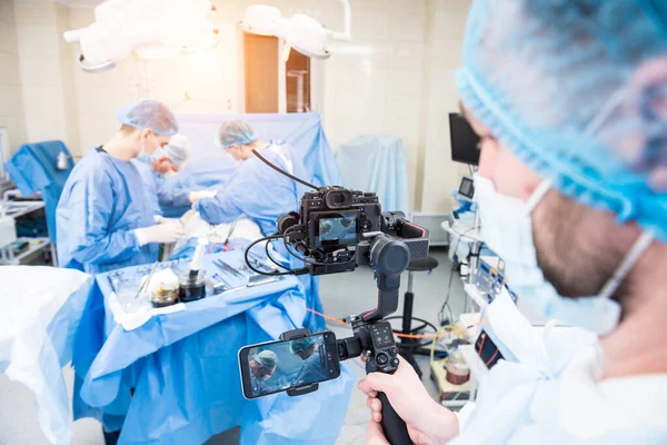 The videographer shoot the surgeon and assistants in the operating room with surgical equipment