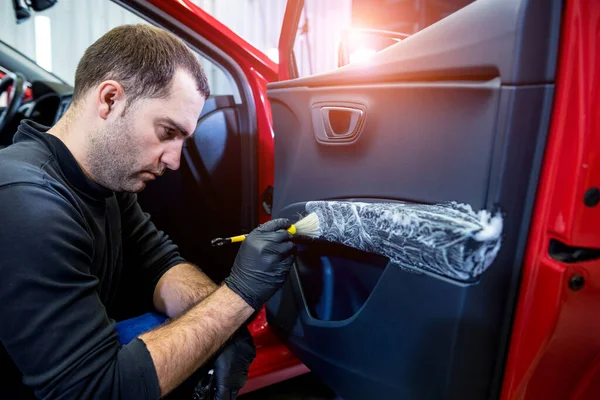 Autoservice-Mitarbeiter reinigt Innenraum mit Spezialbürste — Stockfoto