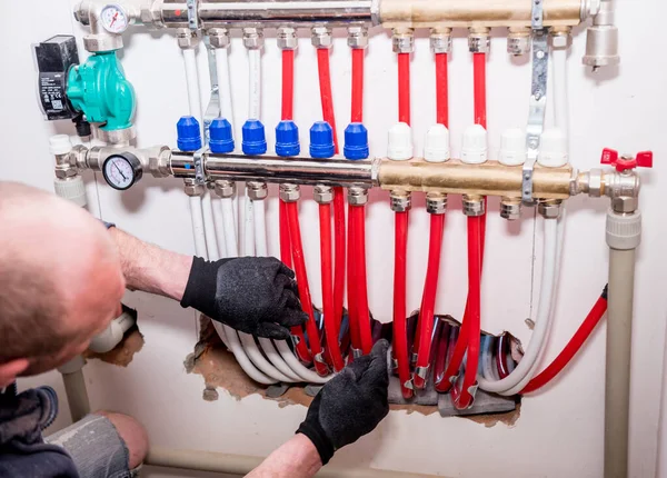 Boru tesisatçısı, alt kattaki ısıtma sistemini eve kurar — Stok fotoğraf