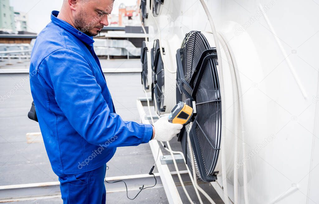 Technician uses a thermal imaging infrared thermometer to check the condensing unit heat exchanger.