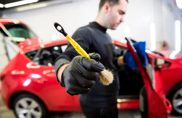 Car service worker czyści wnętrze specjalną szczotką — Zdjęcie stockowe