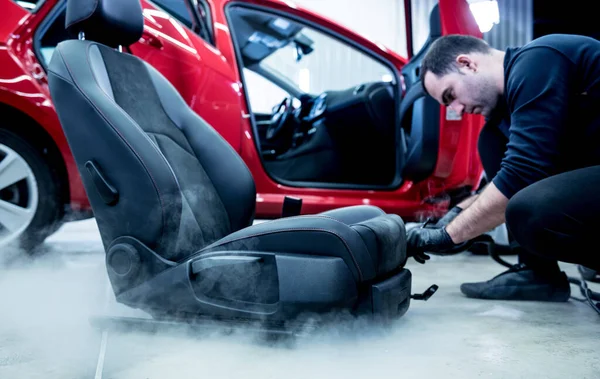 Autoservice-Mitarbeiter reinigt Autositz mit Dampfreiniger — Stockfoto