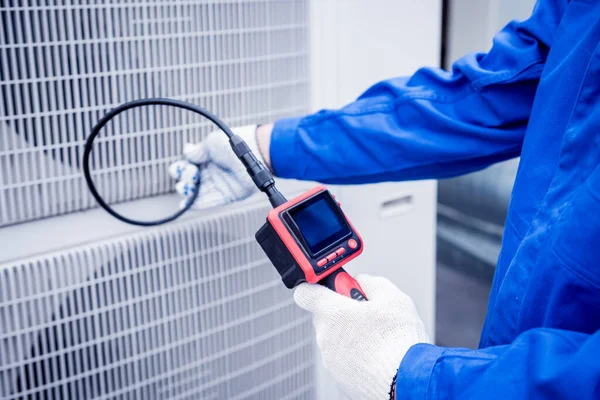 The technician uses a digital camera to check the clogging of the heat exchanger — Stock Photo, Image