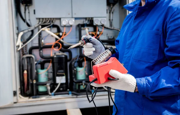 El técnico repara sensores electrónicos de temperatura con un soldador electrónico —  Fotos de Stock