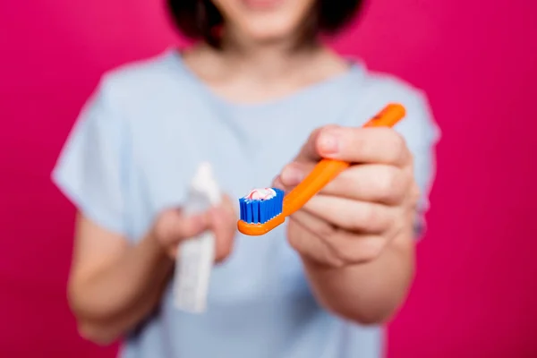 Schöne glückliche junge Frau mit Zahnbürste auf leerem rosa Hintergrund — Stockfoto