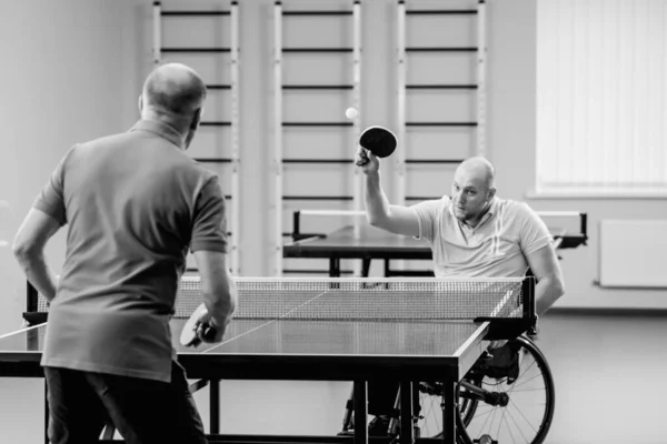 Adulto discapacitado en silla de ruedas jugar al tenis de mesa con su entrenador — Foto de Stock