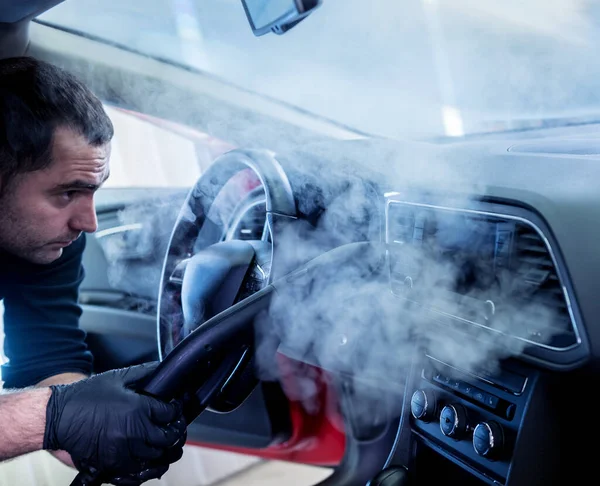 Trabajador de servicio de coches limpia el interior con un limpiador de vapor —  Fotos de Stock