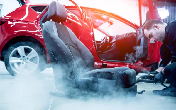 Autoservice-Mitarbeiter reinigt Autositz mit Dampfreiniger — Stockfoto