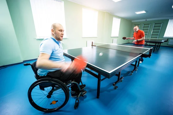 Adulto discapacitado en silla de ruedas jugar al tenis de mesa con su entrenador —  Fotos de Stock