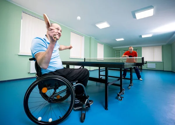 Behinderter Mann im Rollstuhl spielt mit seinem Trainer Tischtennis — Stockfoto