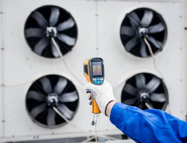 Técnico utiliza un termómetro infrarrojo de imagen térmica para comprobar el intercambiador de calor de la unidad de condensación. —  Fotos de Stock