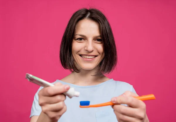 Beautiful happy young woman with toothbrush on blank pink background — Stock Photo, Image