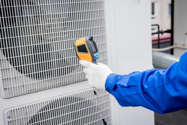 Técnico utiliza un termómetro infrarrojo de imagen térmica para comprobar el intercambiador de calor de la unidad de condensación. —  Fotos de Stock