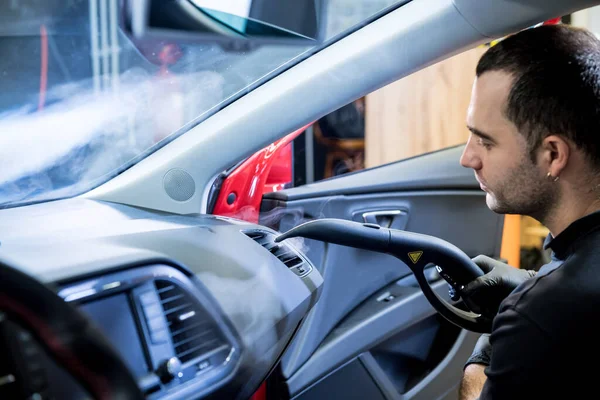 Autoservice-Mitarbeiter säubert Innenraum mit Dampfreiniger — Stockfoto