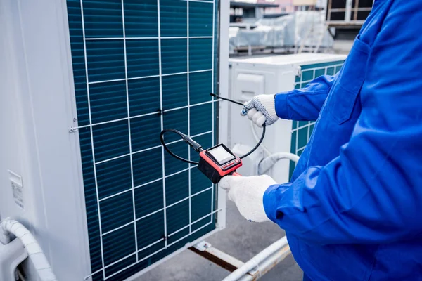 El técnico utiliza una cámara digital para comprobar la obstrucción del intercambiador de calor —  Fotos de Stock