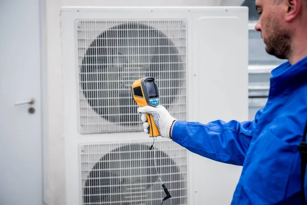 Técnico utiliza un termómetro infrarrojo de imagen térmica para comprobar el intercambiador de calor de la unidad de condensación. —  Fotos de Stock