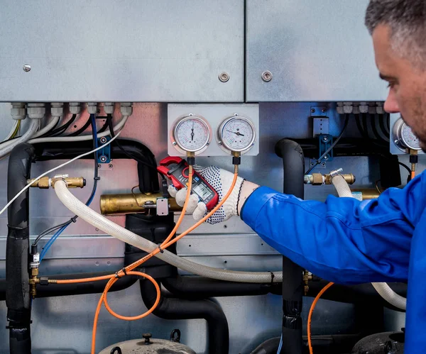 El técnico comprueba las líneas eléctricas del intercambiador de calor con abrazaderas de corriente —  Fotos de Stock