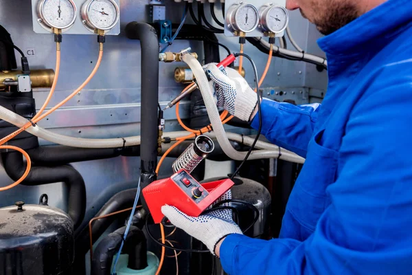 기술자는 전기 납땜 철로 전기 온도 감지기를 수리한다 — 스톡 사진