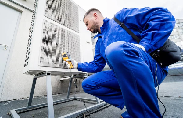 Technician uses a thermal imaging infrared thermometer to check the condensing unit heat exchanger.