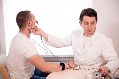Tıbbi merkezde elektromiyografi kullanan hasta sinirleri test ediliyor.