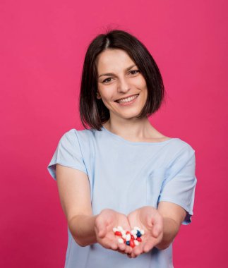 Elinde bir sürü hap tutan güzel bir genç kadın.
