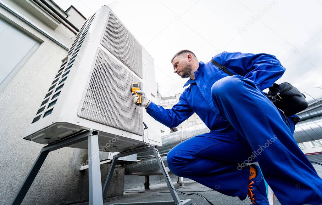 Technician uses a thermal imaging infrared thermometer to check the condensing unit heat exchanger.