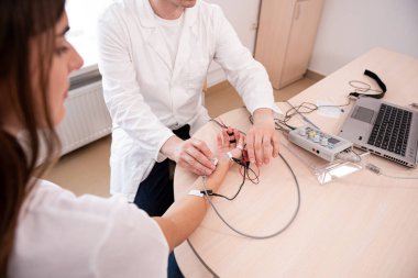 Tıbbi merkezde elektromiyografi kullanan hasta sinirleri test ediliyor.