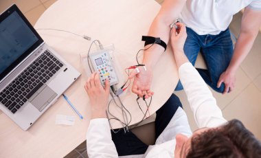 Tıbbi merkezde elektromiyografi kullanan hasta sinirleri test ediliyor.