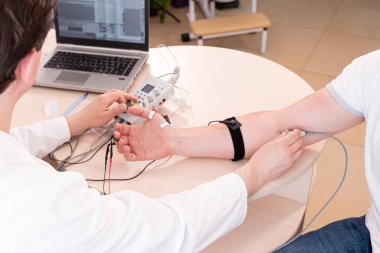 Tıbbi merkezde elektromiyografi kullanan hasta sinirleri test ediliyor.