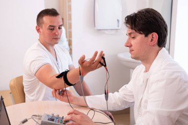 Tıbbi merkezde elektromiyografi kullanan hasta sinirleri test ediliyor.