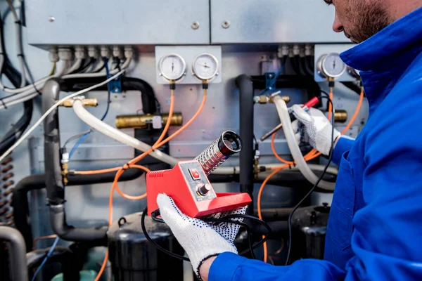 Elektronik ısı sensörlerini elektronik lehimleme demiriyle tamir eden teknisyen. — Stok fotoğraf