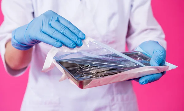 Donna dentista apre un pacchetto di strumenti dentali sterili — Foto Stock