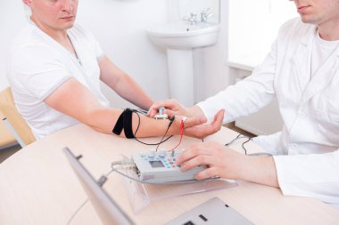 Tıbbi merkezde elektromiyografi kullanan hasta sinirleri test ediliyor.
