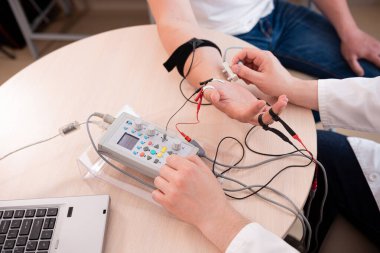 Tıbbi merkezde elektromiyografi kullanan hasta sinirleri test ediliyor.