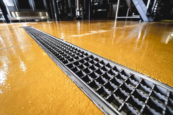 Dreno de piso de aço inoxidável em uma fábrica de cerveja moderna — Fotografia de Stock